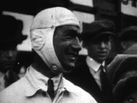 A smiling Testor in tie and ancient leather flying helmet
