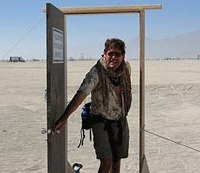 PL looking through a free-standing door, in desert