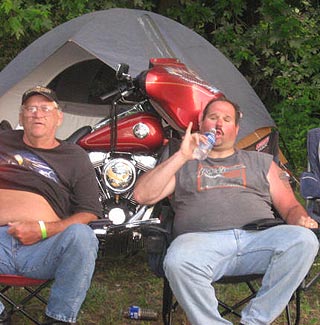 bikers in front of shiny bike and tent